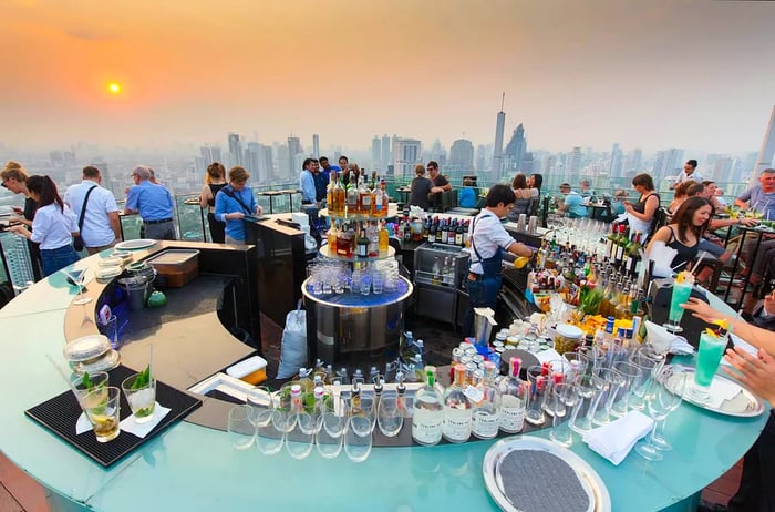 People sipping drinks and soaking in the sunset at the Octave rooftop bar located in the Marriott tower hotel in the Thong Lor district, Bangkok, Thailand