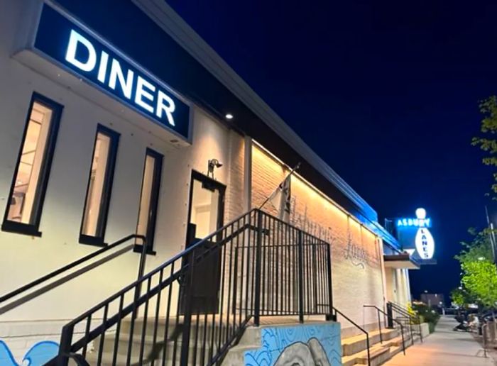 The exterior of the Diner at Asbury Lanes illuminated at night.