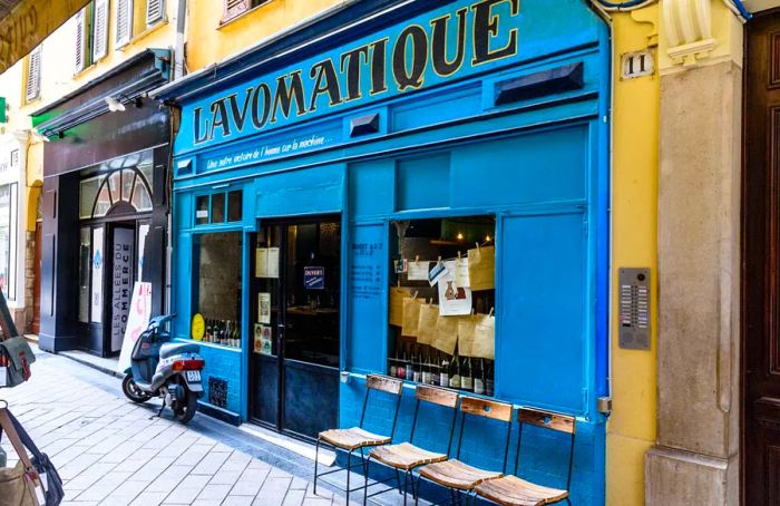 A bright blue restaurant exterior with chairs arranged on the sidewalk outside.