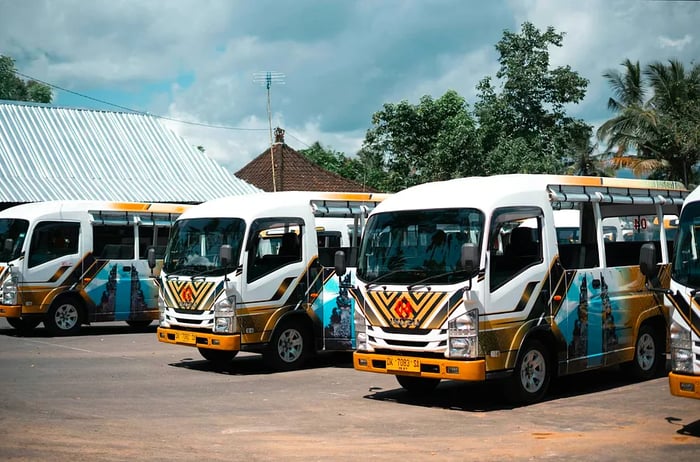 A line of minibuses waits at a bus terminal