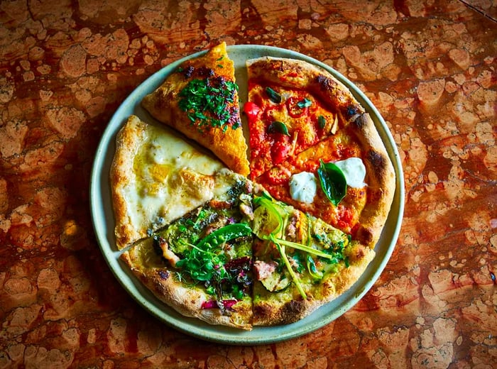 A platter showcasing slices of six different pizzas, each adorned with a variety of toppings.