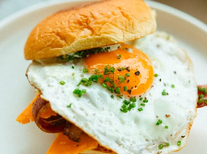 A fluffy bun is topped with a fried egg, making it the star of the sandwich.