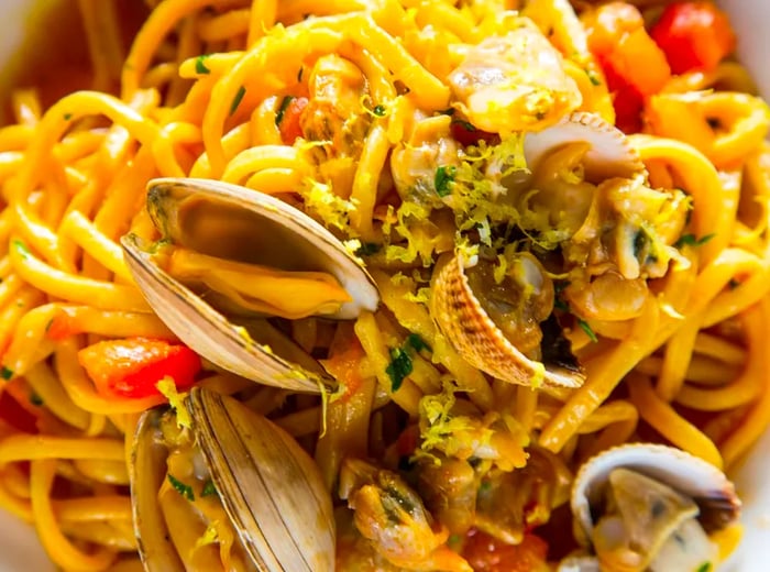 A close-up view of spaghetti adorned with clams.