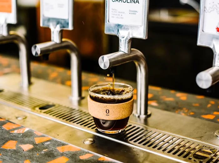 A coffee cup positioned under a tap.