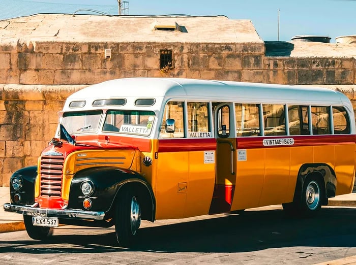 A classic vintage bus parked in the sunny streets of Valletta, Malta. 