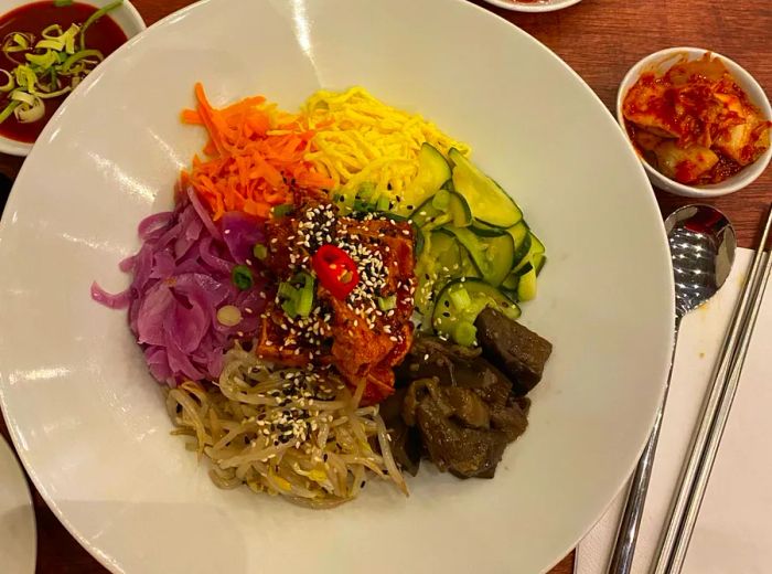 A platter of assorted pickled vegetables accompanied by dipping sauces.