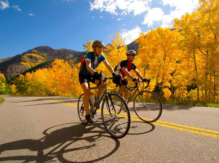 Two cyclists enjoying the vibrant fall foliage in Aspen, Colorado, USA