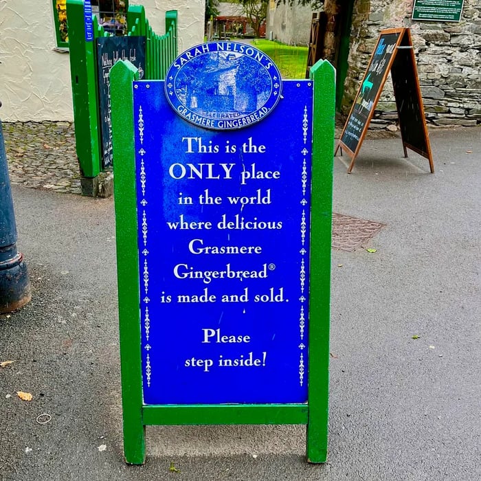 A sandwich board announcing: This is the ONLY place in the world where you can find the delectable Grasmere Gingerbread. Please come inside!