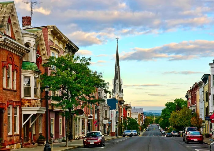 Historic buildings line a serene rural street in New York State at dawn.