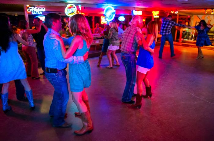 People enjoying country music and dancing in the Broken Spoke dance hall in Austin, Texas, USA