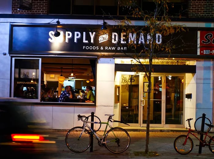 The exterior of a bar illuminated at night.