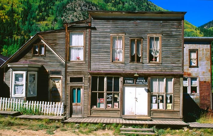 The facade of a historic wooden post office in an abandoned town