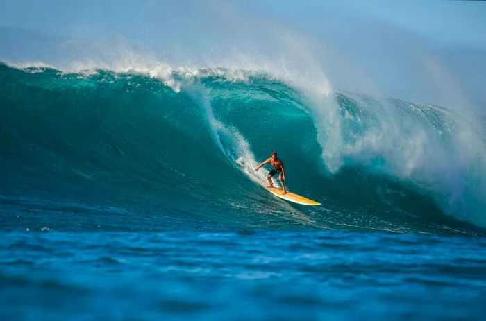 A surfer tackling a big wave at Waimea Bay, North Shore, Oahu, Hawaii, USA