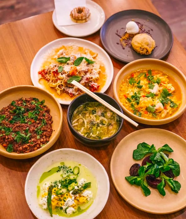 A wooden table adorned with an array of meats, vegetables, and hearty stews