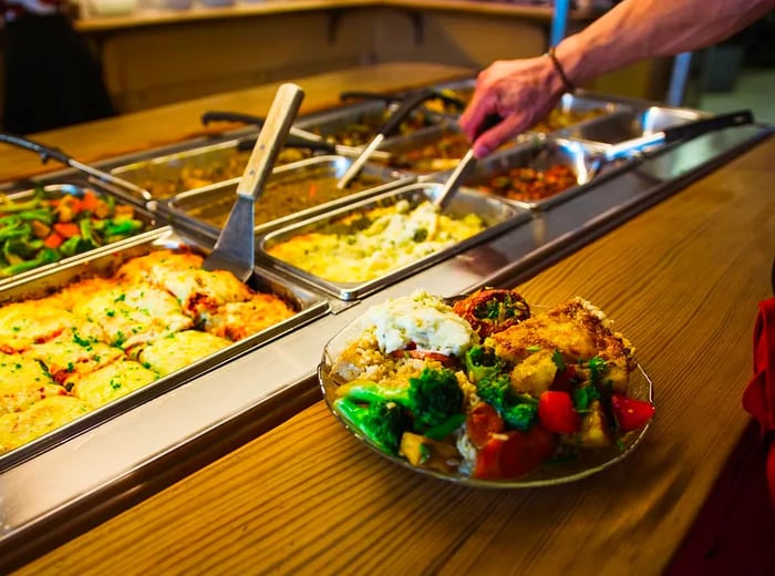 A platter brimming with vegetables alongside a buffet of various dishes.