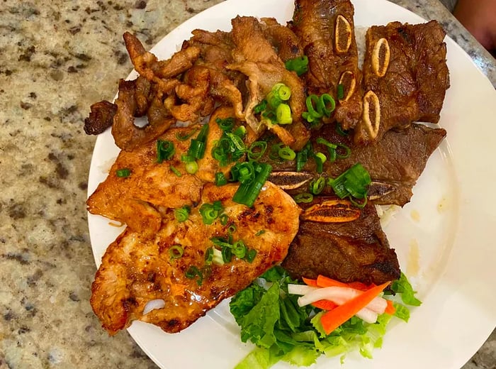 A platter featuring a variety of ribs and meats accompanied by a fresh salad.