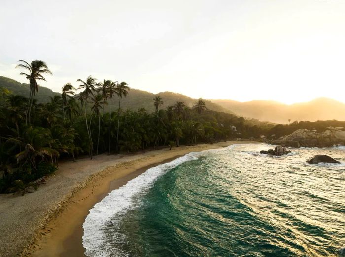 Aerial view of Cabo San Juan del Guia in Tayrona National Park, showcasing the tropical Caribbean coast with palm trees and sandy beaches in Colombia, South America.