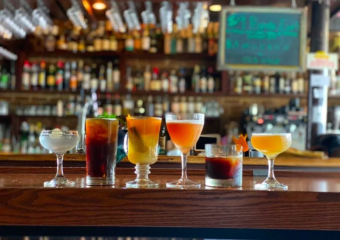 A selection of cocktails lined up on the bar.