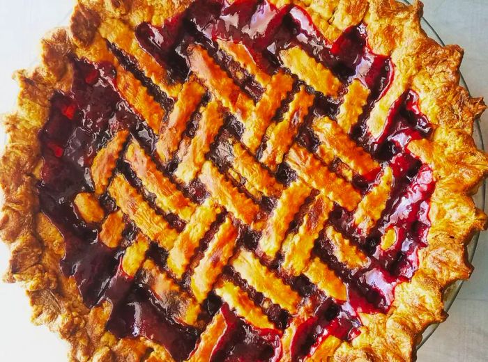 A berry pie topped with a beautifully woven lattice crust.