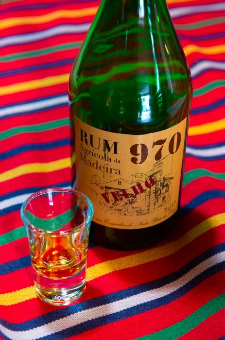 A bottle of rum next to a poured glass.