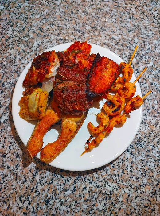 An assortment of grilled seafood presented against a textured backdrop.