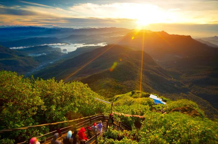 Pilgrims make their way down the narrow stairway, greeted by breathtaking views of the sunrise from the summit of Adam’s Peak, Sri Lanka.