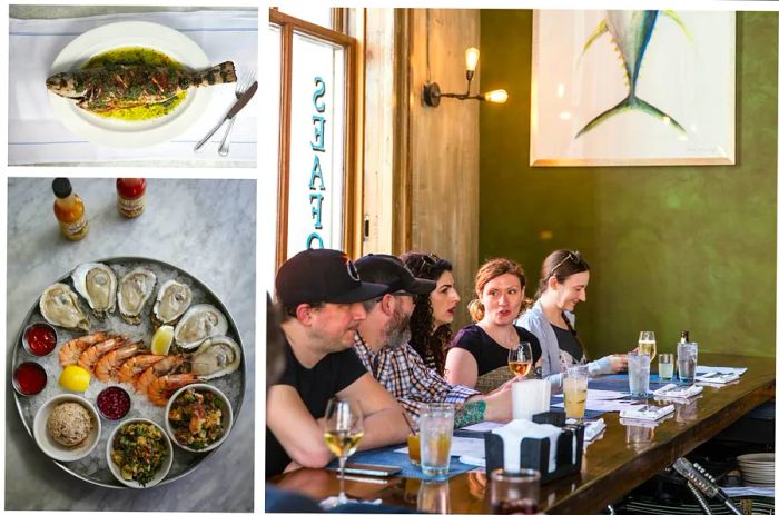 A whole fish, a platter of shrimp and oysters, and a lively group enjoying drinks at a bar in a restaurant