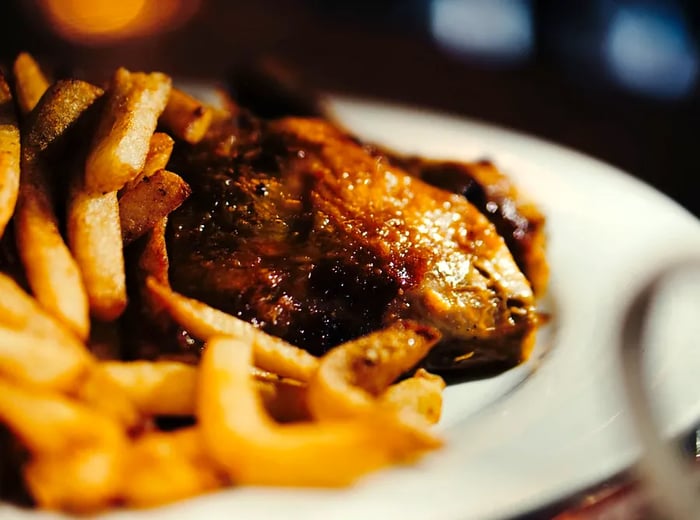 A serving of roasted chicken paired with a generous portion of French fries.