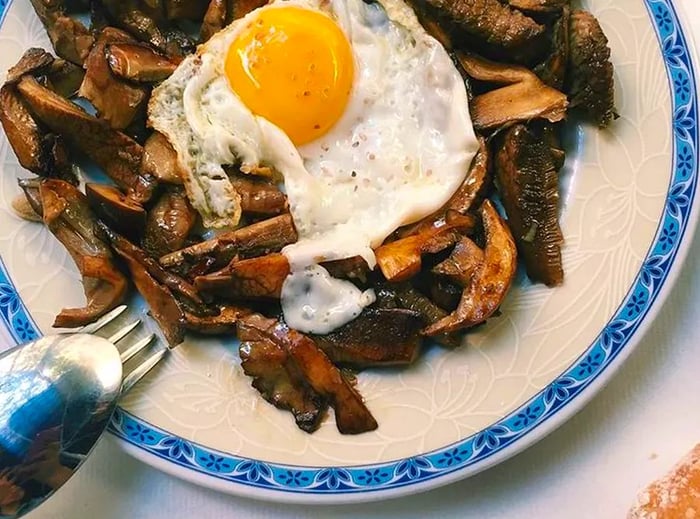 A dish featuring mushrooms topped with a sunny-side-up egg.