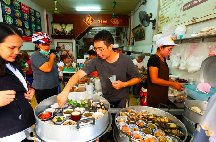 Servers bustling about, taking orders and serving dishes in a lively dim sum restaurant.