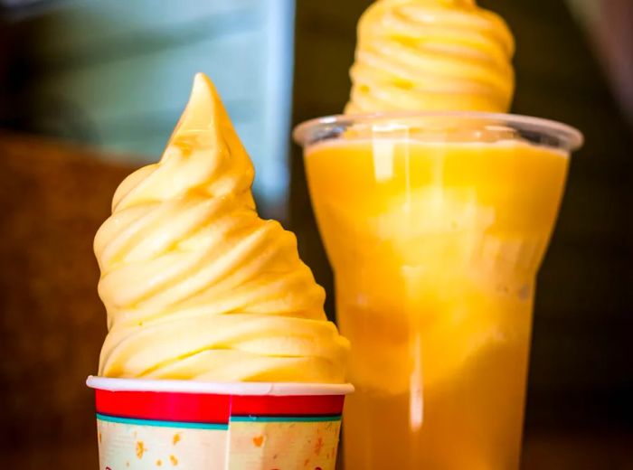 Two soft serve delights, one in a cup and the other adorning a drink.