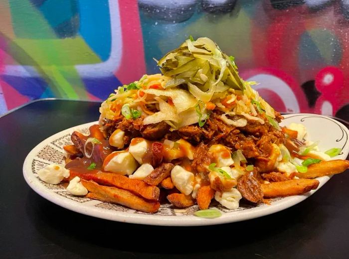 A hearty serving of poutine overflowing with toppings.