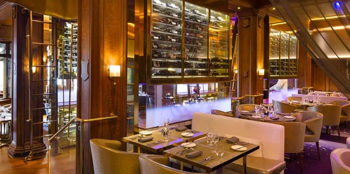 A luxurious restaurant interior featuring a glass wall lined with wine bottles.