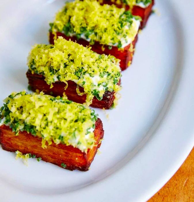 Stacked, fried potatoes topped with a variety of creamy garnishes.