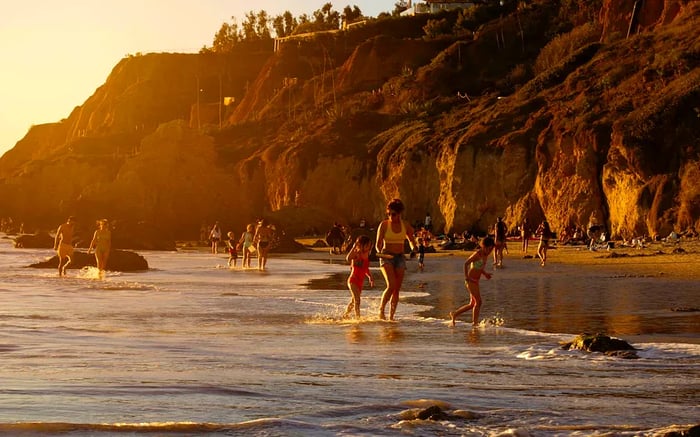 A sunset view of revelers enjoying El Matador Beach, Malibu, California, USA