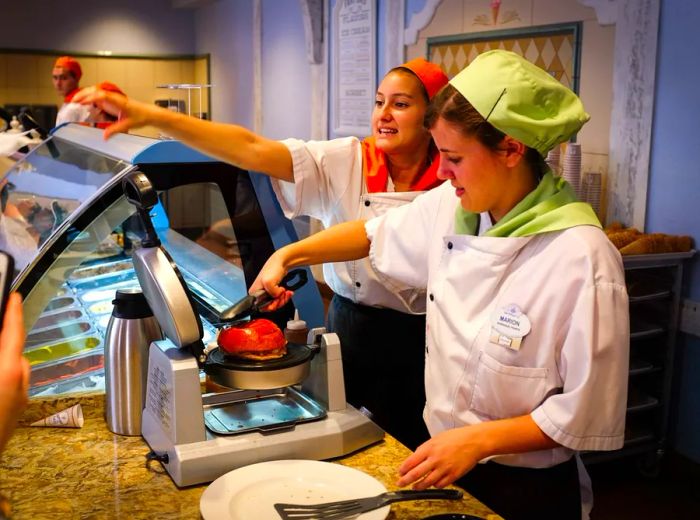 A server prepares the dessert behind the counter.