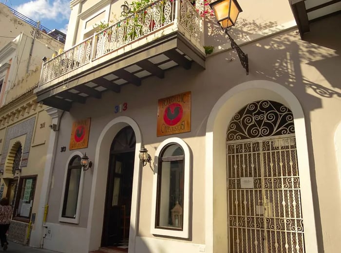 The exterior of a building showcasing classic San Juan Spanish colonial architecture, complete with signage for Bodega Chic restaurant.