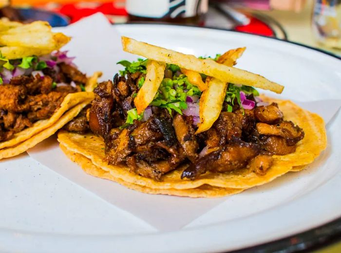 Two tacos garnished with seitan steak.