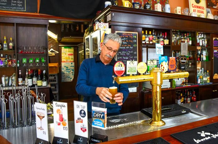 A bartender serving beer at a pub in Australia