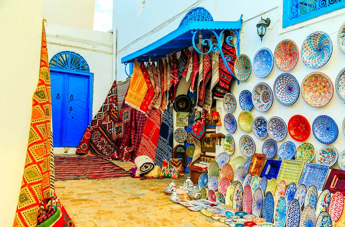 Display of earthenware souvenirs and carpets at a Tunisian market.