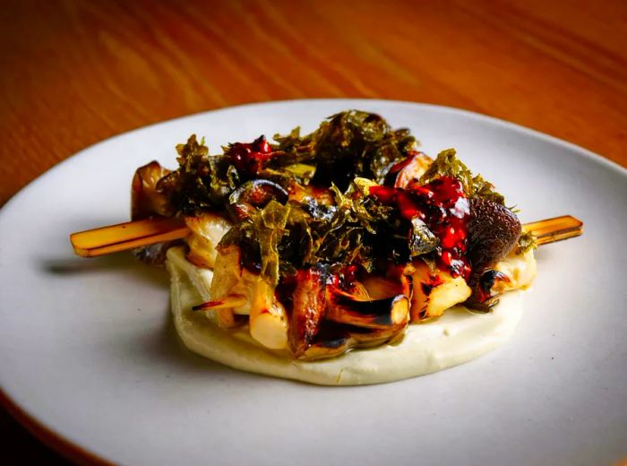 Two substantial mushroom skewers resting on a velvety sauce bed.