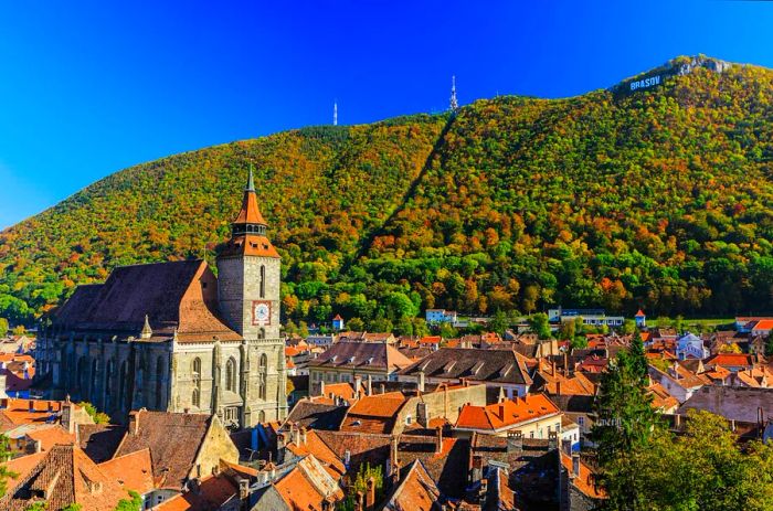 A picturesque view of Brasov in Transylvania, showcasing the rooftops with the Black Church basking in sunlight.