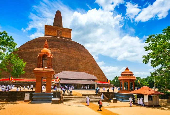 Pilgrims and visitors assemble at the base of the Abhayagiri Vihāra Monastery in Anuradhapura, Sri Lanka.