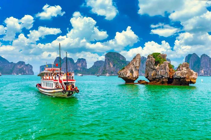 A boat glides past islands in Halong Bay, Vietnam