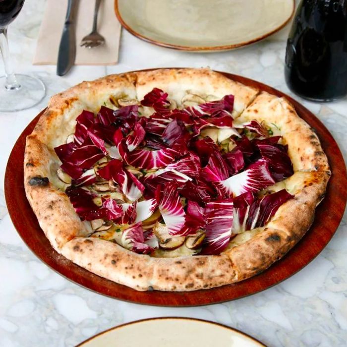 A white pizza garnished with thin slices of radicchio.