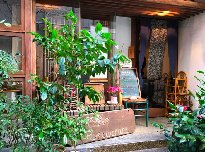 A charming restaurant facade adorned with potted plants.