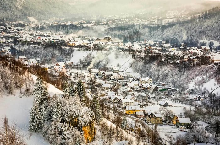 A picturesque snowy scene of village homes in Bran, Transylvania, Romania.