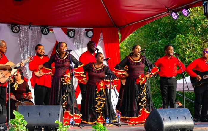 A parang band dressed in vibrant red and black outfits performs during a Christmas festival in Lopinot Village, Trinidad.