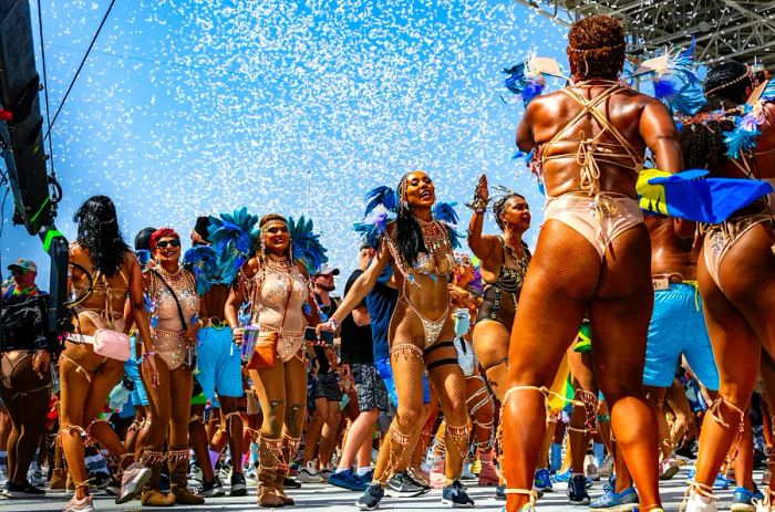 Female masqueraders in colorful costumes revel in the Bliss Carnival presentation, Port of Spain, Trinidad.