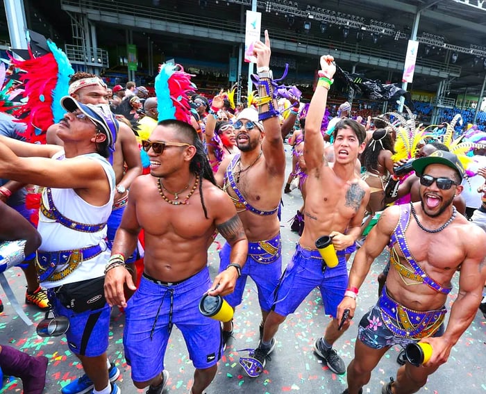 Men in vibrant purple costumes entertain the crowd during Carnival celebrations in Trinidad.